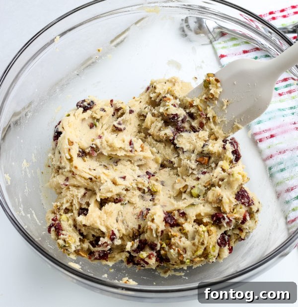 Mixing cranberries and pistachios into cookie dough