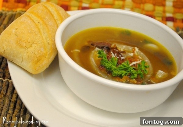 Delicious French Onion Soup topped with melted gruyere cheese, a perfect comfort food recipe for cold weather.