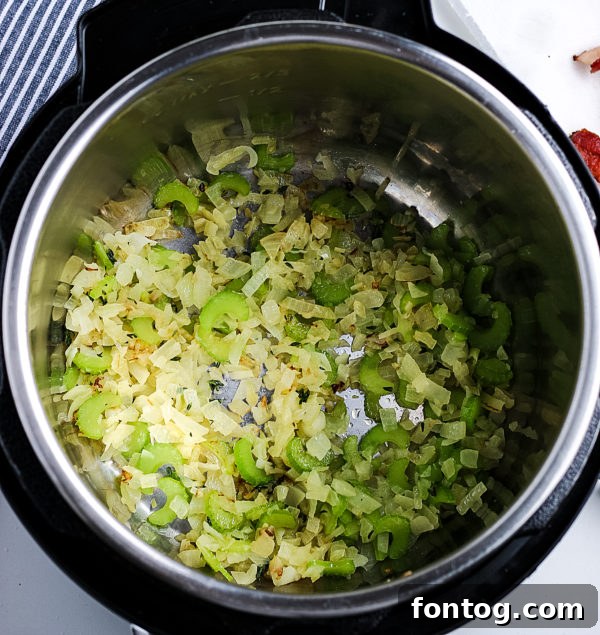 Close-up of crispy bacon in a Ninja Foodi pot, ready to be crumbled for potato soup.