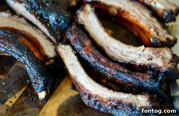 Perfectly grilled baby back ribs from Ninja Foodi Grill, glistening with BBQ sauce.