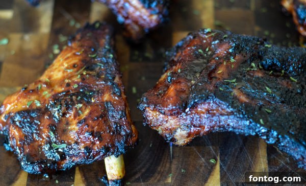 Close-up of perfectly cooked baby back ribs on a cutting board, ready to serve.