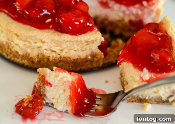 A whole Ninja Foodi Cheesecake with cherry topping, showcasing its smooth texture before slicing.