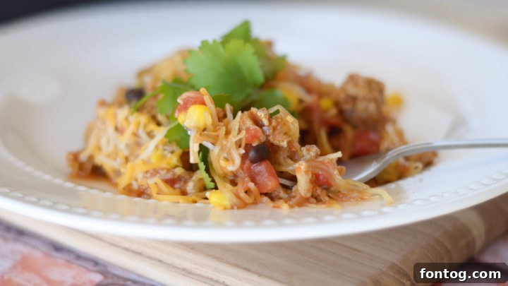 A hearty spaghetti squash taco skillet, filled with savory ground meat and toppings.
