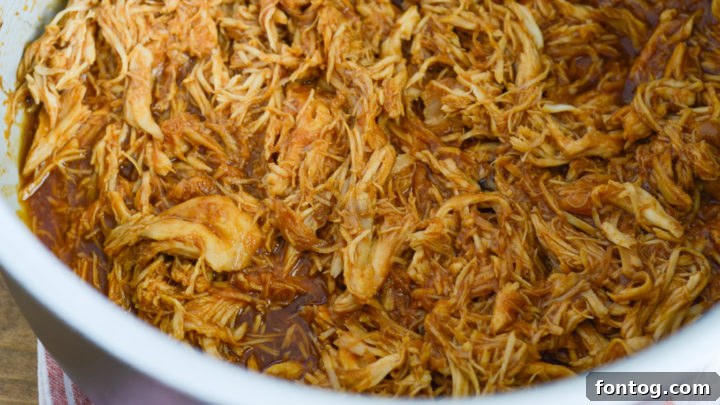 Shredded BBQ chicken, cooked to tender perfection in a Ninja Foodi slow cooker.