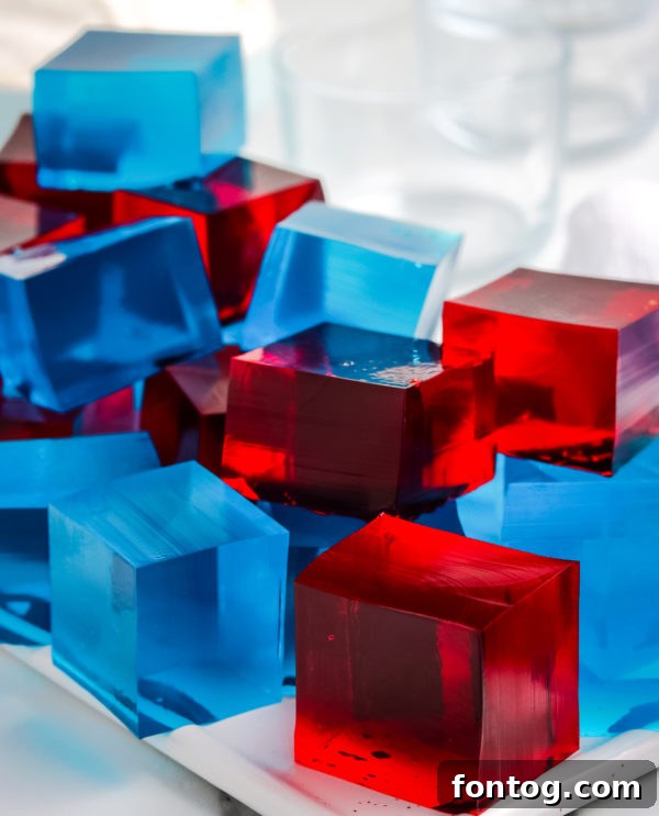 Close-up of neatly cut red and blue Jello Jigglers, showing their firm texture and vibrant colors.