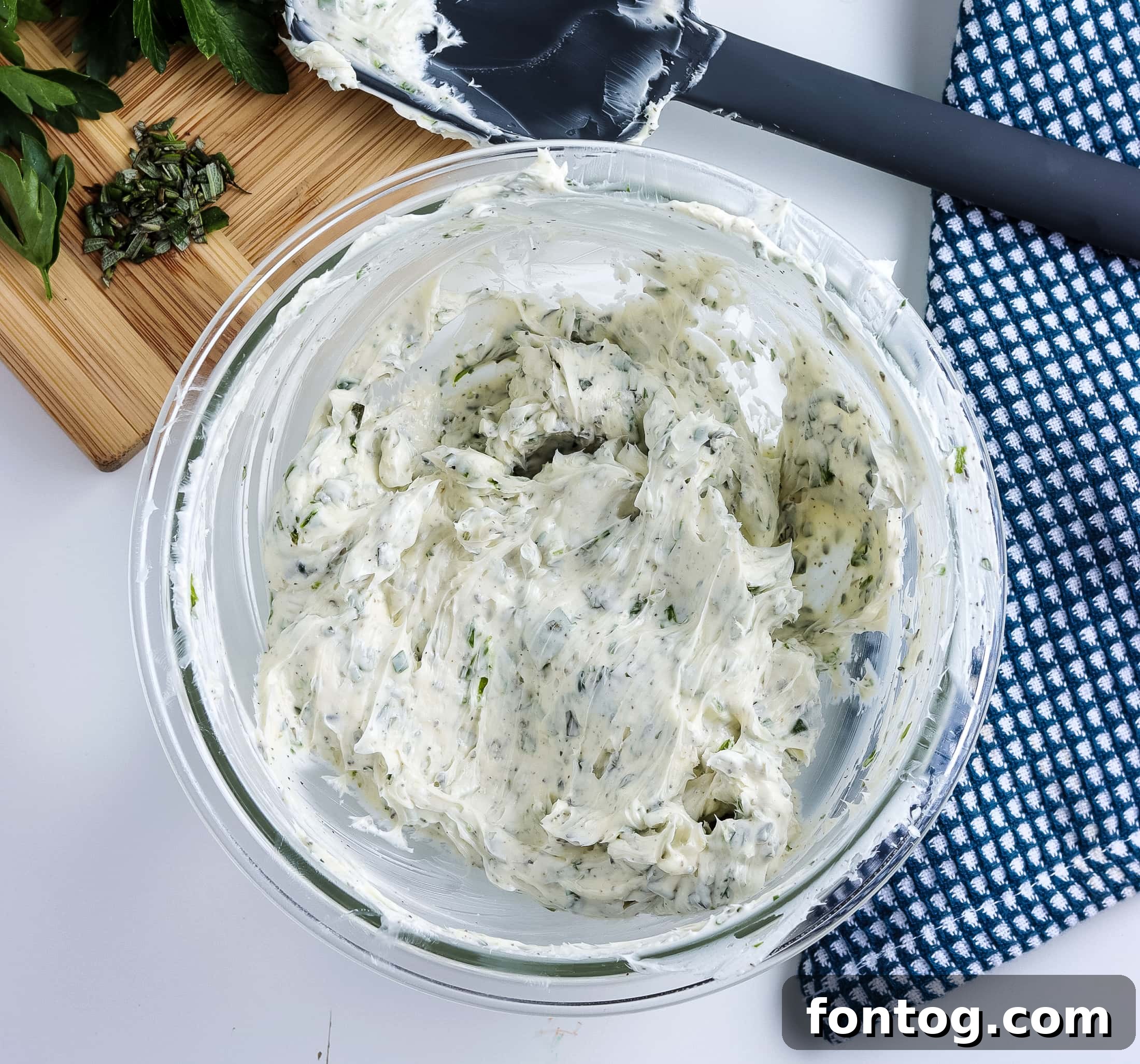 Mixing fresh herbs into softened butter with a handheld mixer
