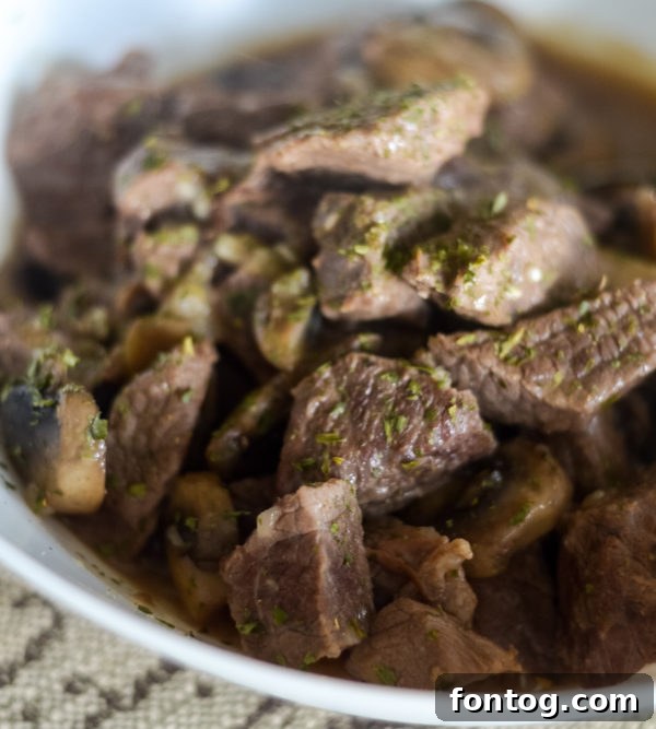 ninja foodi beef tips served over mashed potatoes with a sprinkle of parsley