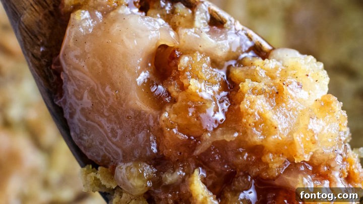 Hearty Crockpot Apple Cobbler, bubbling with spiced apples and a golden topping.
