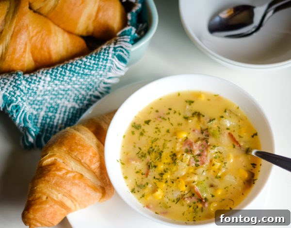 Ninja Foodi Corn Chowder in a bowl, garnished with fresh herbs and bacon.