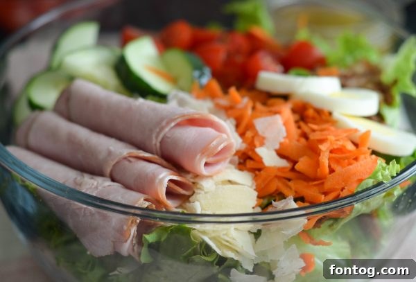 Close-up of Chef Salad ingredients including hard-boiled eggs, deli meat, and fresh vegetables.