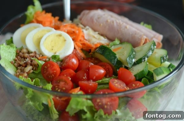 Chef Salad with rolled deli meats, fresh greens, and various toppings.