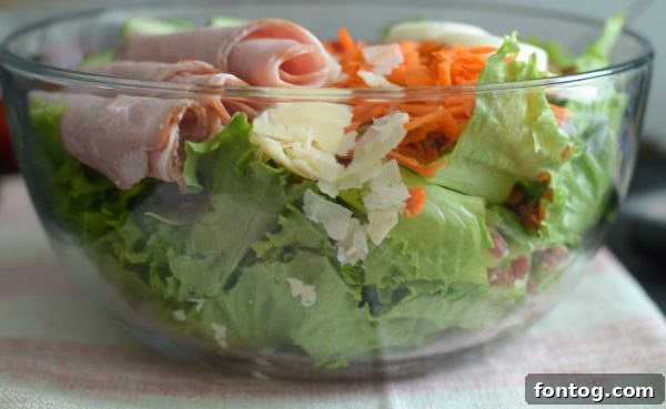 Chef salad ingredients arranged neatly on a platter, highlighting the vibrant colors.