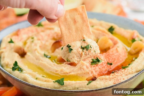 Pouring tahini sauce into a bowl, illustrating a key ingredient for creamy hummus.