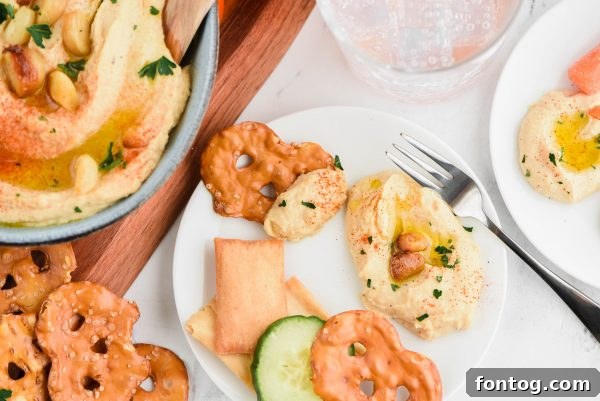A close-up view of roasted garlic hummus in a white bowl, showing its smooth texture.