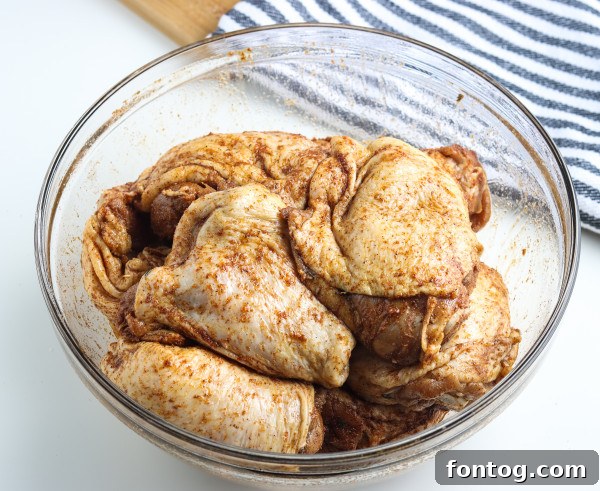 Close-up of seasoned chicken thighs ready for the smoker.