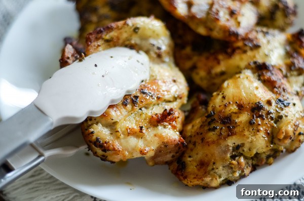 Close-up of chicken thighs generously coated in green basil pesto