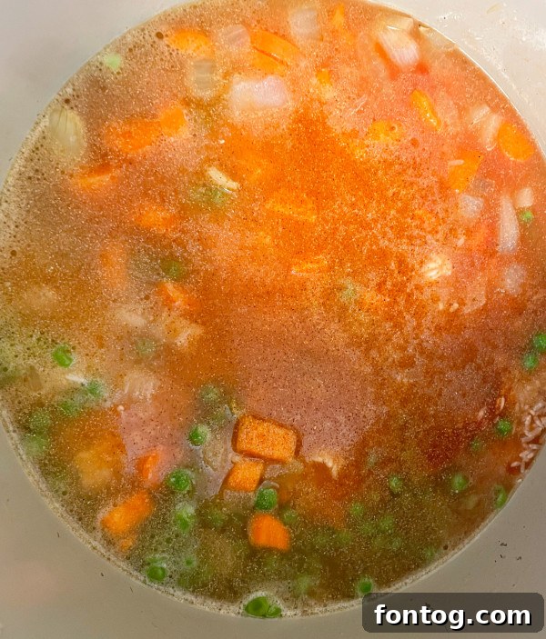 Close-up of diced onions sautéing in olive oil within the Ninja Foodi pot.
