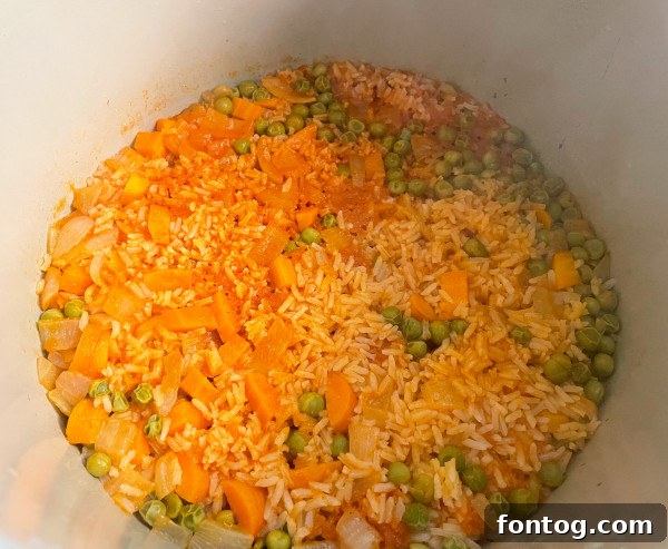 Freshly diced carrots and frozen peas, ready to be added to the Ninja Foodi Spanish Rice.