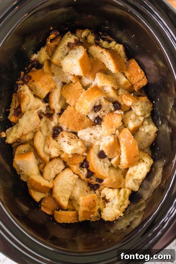S'mores French Toast Casserole in slow cooker, topped with melted chocolate and marshmallows after cooking.