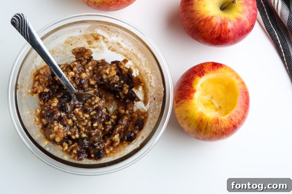 A bowl containing cinnamon, dried cranberries, and chopped walnuts – key ingredients for the apple filling