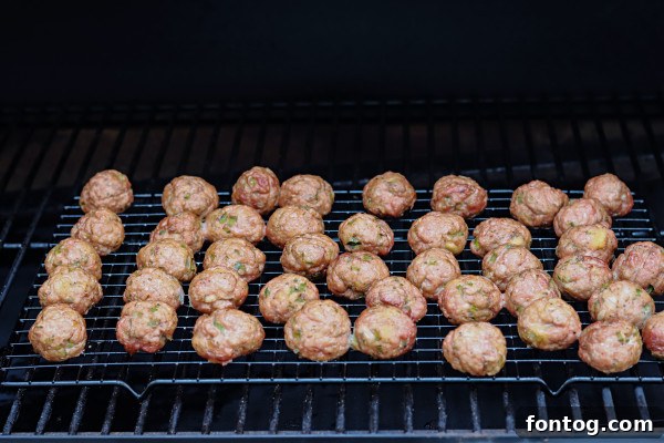 Hand mixing smoked meatball ingredients in a large bowl