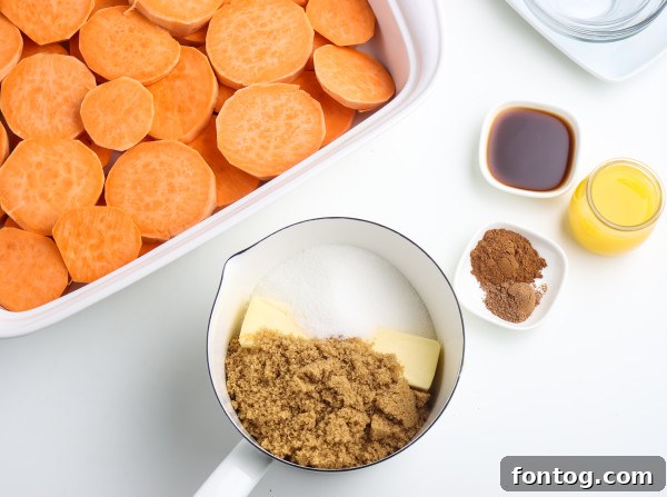 Arranging the sliced yams or sweet potatoes in a baking dish before adding the sauce