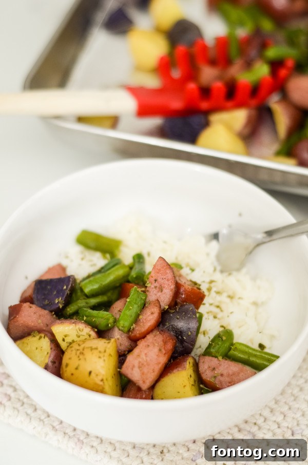Effortless Sausage and Veggie Sheet Pan Dinner 7 Sheet Pan Sausage and Vegetables with a serving spoon