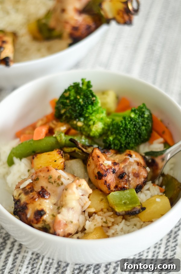 Sweet and Sour Chicken Skewers with Sauce: Assembled skewers coated in sauce, ready for cooking, with extra sauce reserved in a bowl.