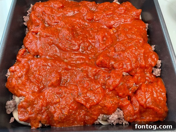 Layered tortellini bake in a baking dish before cooking