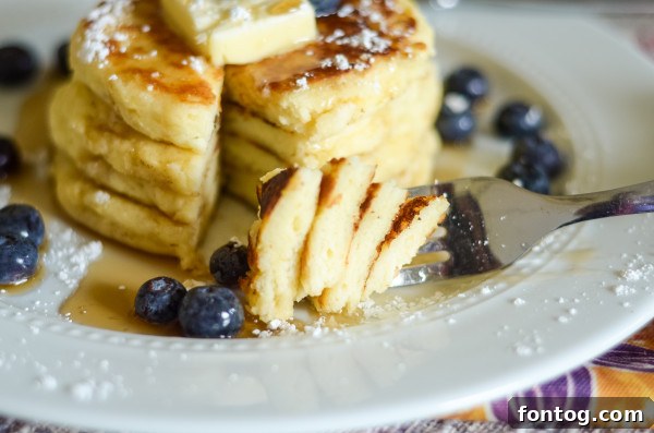 Stack of fluffy gluten-free pancakes drizzled with syrup, made with homemade bisquick