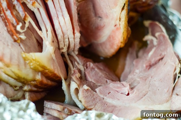 Sliced double-smoked ham presented beautifully on a cutting board with herbs.