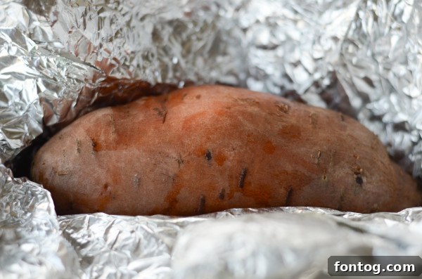 Ultimate Pellet Grill Smoked Sweet Potatoes 3 Close-up of a sweet potato being checked with an instant-read thermometer to ensure perfect doneness on the pellet grill.