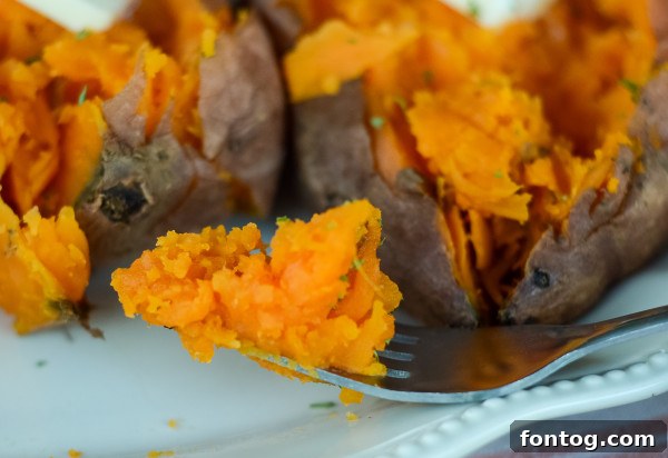 Ultimate Pellet Grill Smoked Sweet Potatoes 7 A perfectly smoked sweet potato with melted butter and cinnamon on a plate, ready to be served.