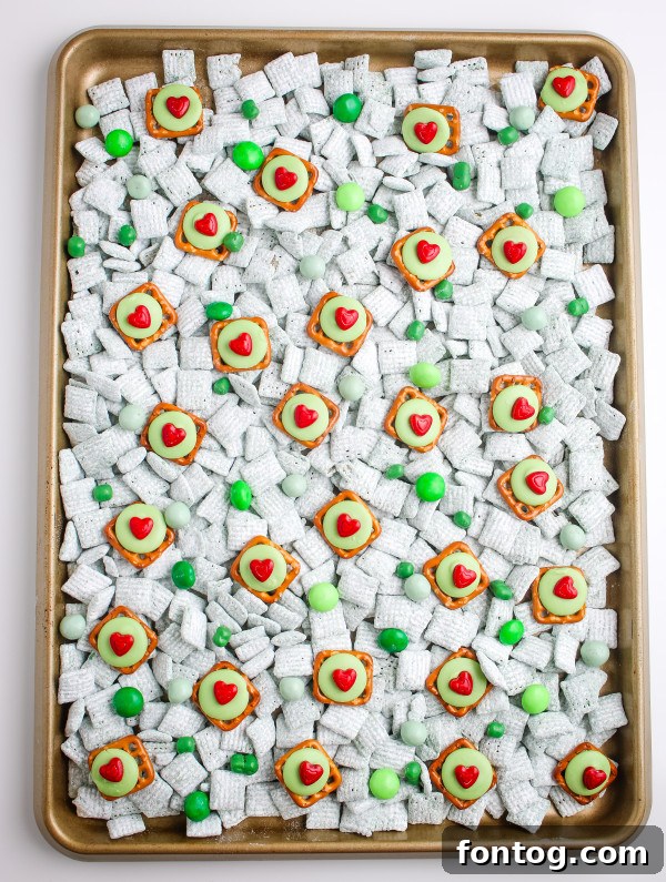 Delicious Grinch Pretzel Bites arranged on a platter, showcasing their vibrant green color and red heart sprinkles, ready for a festive snack mix or holiday gathering.