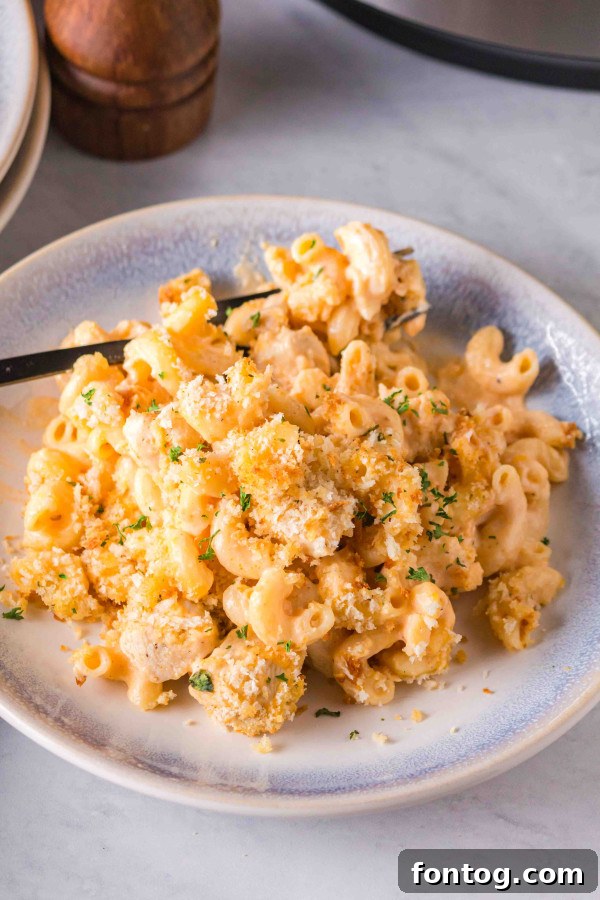 Ninja Foodi Buffalo Macaroni and Cheese with chicken pieces and a crispy topping.