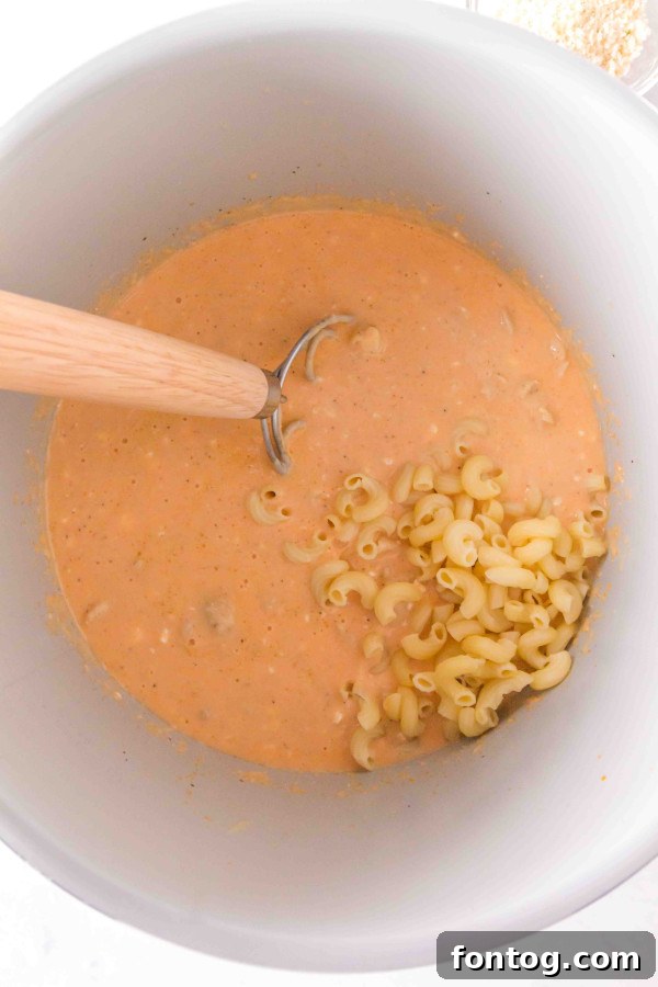 Cooked macaroni pasta in a bowl, ready to be combined with the sauce.