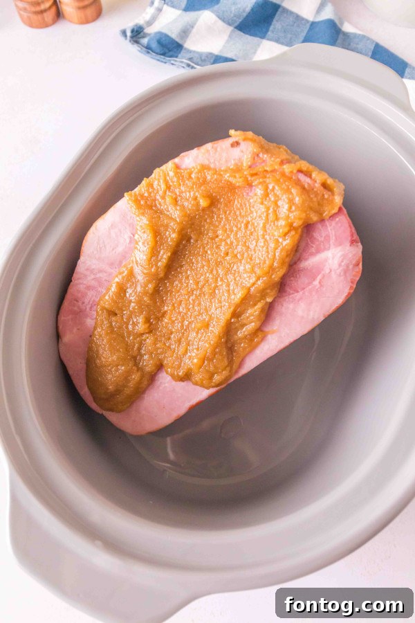 Close up of brown sugar glaze being poured over ham