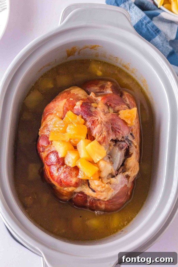 Cooked brown sugar slow cooker ham being sliced