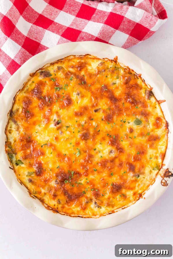 Homestyle Cheeseburger Pie 2 Gluten-free cheeseburger pie slice on a plate, garnished with fresh herbs