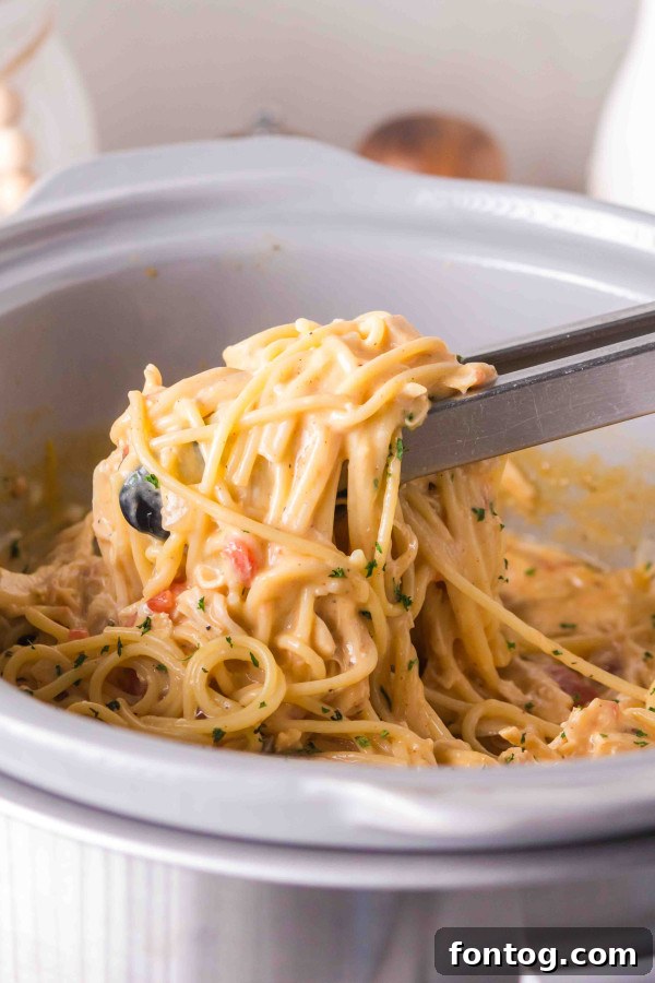 Set It And Forget It Gluten-Free Chicken Spaghetti 9 mixing spaghetti into gluten-free crockpot chicken spaghetti