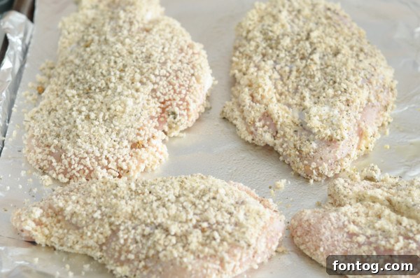 Chicken breast being coated in breadcrumbs inside a bag