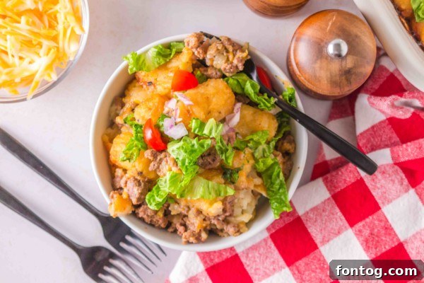 Close-up of a portion of Big Mac Tater Tot Casserole, showcasing crispy tots and the cheesy beef layer.