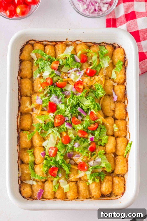 Big Mac Tater Tot Casserole in a 9x13 baking dish, topped with tater tots and ready for the oven.