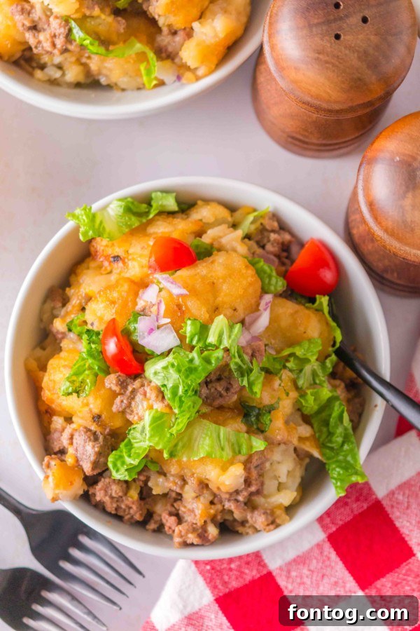 Big Mac Tater Tot Casserole garnished with fresh lettuce and sesame seeds, mimicking a Big Mac.