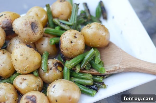 Close-up of seasoned green beans and baby potatoes before grilling