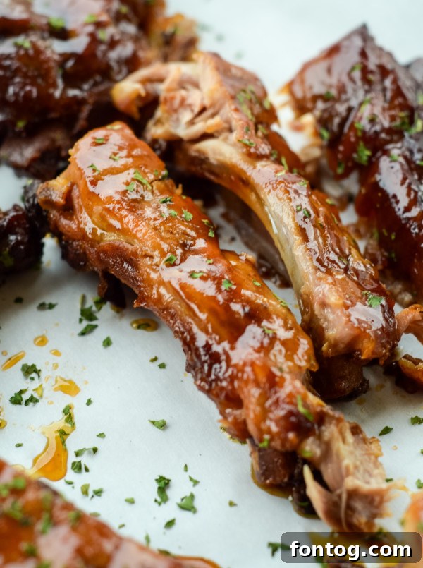 Delicious, fully cooked slow cooker apple bbq ribs on a platter, ready to serve.