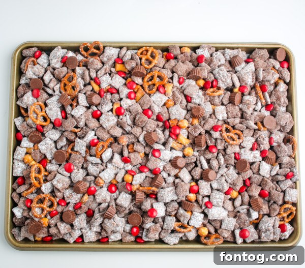 Santa's Gluten Free Reindeer Fuel 7 Gluten-free reindeer chow mix with pretzels and puppy chow cooling on a sheet pan.