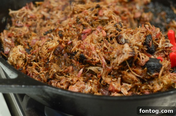 pellet grill smoked pork carnitas in pan to sear