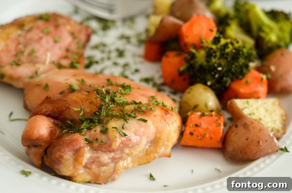 Golden Glazed Chicken Thighs and Roasted Garden Vegetables 5 Cooked sheet pan glazed chicken and vegetables portioned into meal prep containers.