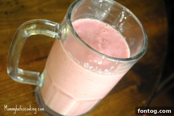 Delicious Wildberry Smoothie in a glass with berries around it.